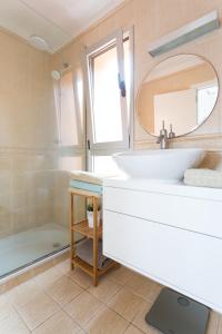 e bagno con lavandino, specchio e vasca. di Modern House With Private Swimming Pool a El Médano