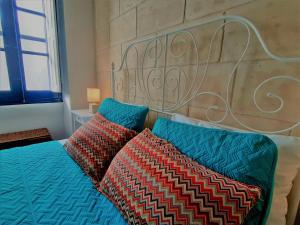 a bedroom with a bed and two pillows at Blueberry House B in Xagħra