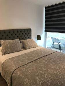 a bedroom with a large bed with a large window at 8,Clínica Las Condes, 3 personas in Santiago