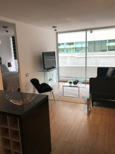 a living room with a couch a table and a tv at 8,Clínica Las Condes, 3 personas in Santiago