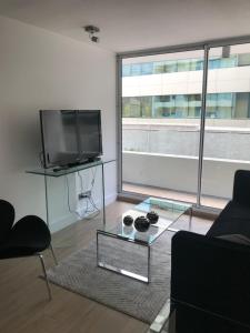 a living room with a tv and a glass table at 8,Clínica Las Condes, 3 personas in Santiago +3 photos