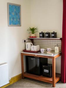 a table with a coffee maker on top of it at Hill View in Binegar +9 photos