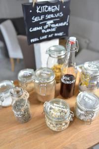 a table with jars of spices and a bottle of honey at Five Point Hostel & Apartments in Gdańsk