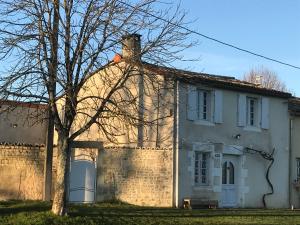 a white house with a tree in front of it at La Maison de Josephine in Montignac-Charente