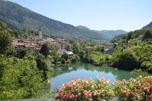 a view of a town and a river with flowers at Penzion Šterk in Most na Soči