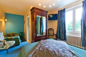 a bedroom with a bed and a mirror and a window at Relais d'Auvergne in Saint-Gervais-dʼAuvergne