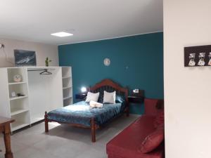 Un dormitorio con una cama y una pared azul. en Departamento 4 Complejo Sol de Oeste, en San Juan