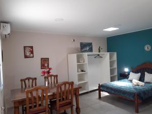 Habitación con mesa, cama, mesa y sillas. en Departamento 4 Complejo Sol de Oeste, en San Juan