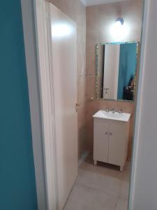 un baño con lavabo y espejo en Departamento 4 Complejo Sol de Oeste, en San Juan