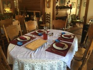 mesa de comedor con mantel blanco y mesa en Timber Post Bed & Breakfast, en Nashua