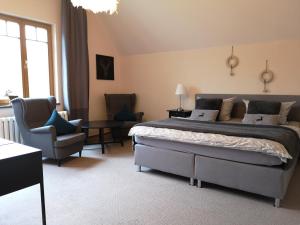um quarto com uma cama grande e uma cadeira em Comfort-Hotel garni Schierker Waldperle - inklusive Wellness em Schierke