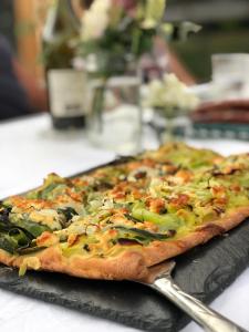a pizza sitting on top of a table with a spatula at Rejaillir in Saint-Ours