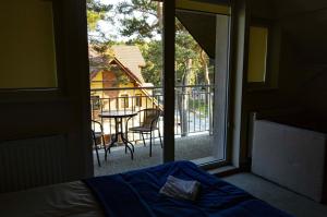 a bedroom with a bed and a view of a balcony at Pensjonat i Restauracja Laguna in Pogorzelica