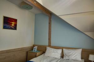 Bett mit weißen Kissen in einem Zimmer in der Unterkunft Pensjonat i Restauracja Laguna in Pogorzelica