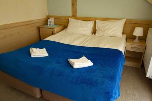 a bedroom with a bed with two white shoes on it at Pensjonat i Restauracja Laguna in Pogorzelica