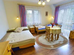a bedroom with a bed and a table and chairs at Willa Modrysówka in Zawoja