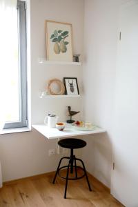 a small white table with a stool in a room at Rejaillir in Saint-Ours