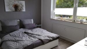 uma cama num quarto com 2 janelas em Ferienwohnungen Fuchs em Duisburg