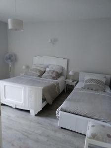 una camera bianca con 2 letti e una lampada di GITE IZALIN AVEC SPA A 20 min du Puy du Fou a Mauléon