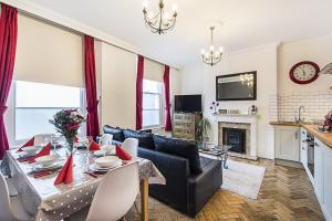 a living room with a black couch and a table at 2Bed Apartment in Camden in London