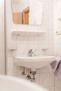 Baño blanco con lavabo y espejo en Appartement Grüner Fidelis, en Sölden