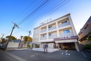 ein Gebäude mit einem Parkplatz davor in der Unterkunft HOTEL ZEN KOHOKU in Yokohama