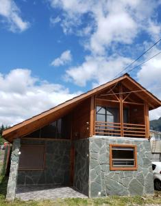 a house with a stone facade with a roof at Aysen Bike Cabañas in Puerto Aisén