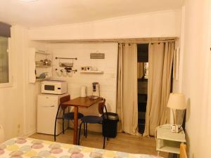 a small kitchen with a table and a microwave at Studio Vue Mer - Idéal Voyageur Solo, à Vélo, à Pied in Perros-Guirec