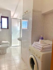 uma casa de banho com uma máquina de lavar roupa e um WC em Apartment Andreana em Tergu