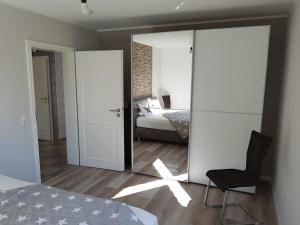 1 dormitorio con cama y espejo en Garden & Hill Ferienwohnung Limburg, en Simmerath