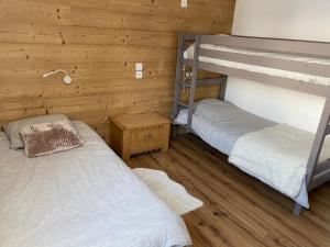 two bunk beds in a room with wooden walls at Plagne Centre - Immeuble Le Mustag - Wifi in Aime-La Plagne