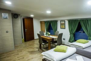 een kamer met twee bedden en een tafel en stoelen bij Villa Zoki - soba dnevni najam in Zagreb