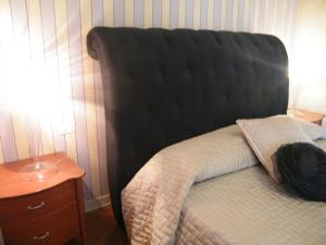 un lit avec tête de lit noire à côté d'une table dans l'établissement Villa Franca Casa Vacanze, à Passirano