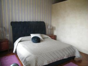 - une chambre avec un lit doté d'une tête de lit noire dans l'établissement Villa Franca Casa Vacanze, à Passirano