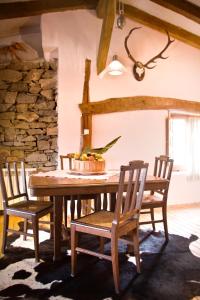 comedor con mesa de madera y sillas en Casa Jardín, en Navalsaz