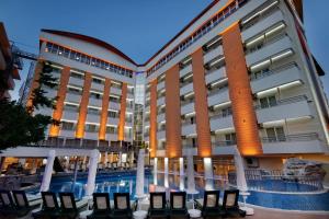 um hotel com piscina em frente a um edifício em Alaiye Kleopatra Hotel em Alanya