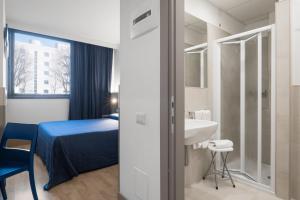 Un dormitorio con una cama, un lavabo y un espejo. en Hotel Martini, en Verona