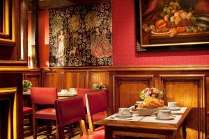 a restaurant with tables and chairs and a painting on the wall at Hotel Left Bank Saint Germain in Paris +36 photos