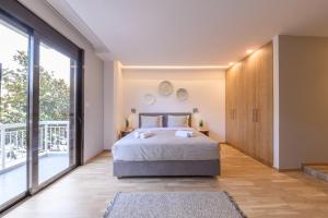 sypialnia z łóżkiem i dużym oknem w obiekcie MAGNOLIA City Suite w mieście Patras