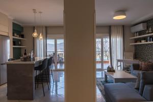 a kitchen and living room with a bar and a couch at Voria Paralia in Kastoria