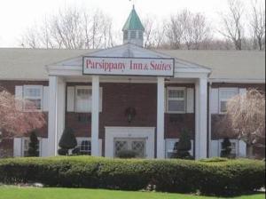 un edificio con un cartel en la parte delantera en The Parsippany Inn and Suites, en Morris Plains