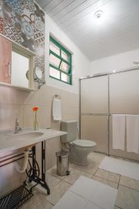 a bathroom with a toilet and a sink and a shower at Mala & Tudo Pousada in Torres +60 photos