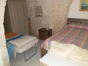 um quarto com 2 camas, uma cadeira e uma mesa em Trullo la Quiete em Alberobello