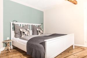 sypialnia z białym łóżkiem z szarymi poduszkami w obiekcie Lober´s Ferienhaus **** w mieście Bretzenheim