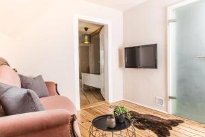 uma sala de estar com um sofá e uma televisão na parede em Lober´s Ferienhaus **** em Bretzenheim