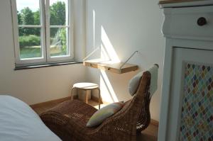 een slaapkamer met een bed en een stoel naast een open haard bij Gîte Bord de Meuse in Namen