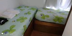 un piccolo letto con foglie verdi sulle lenzuola di Mi Capricho a Barra de Maldonado