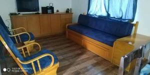 a living room with a blue couch and a tv at Mi Capricho in Barra de Maldonado
