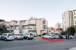 un groupe de voitures garées dans un parking à côté des bâtiments dans l'établissement Dubrovnik Spectrum Rooms, à Dubrovnik