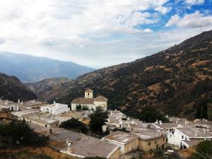 una pequeña ciudad en un valle con montañas en el fondo en Casa El Rincón del Ángel, en Bubión